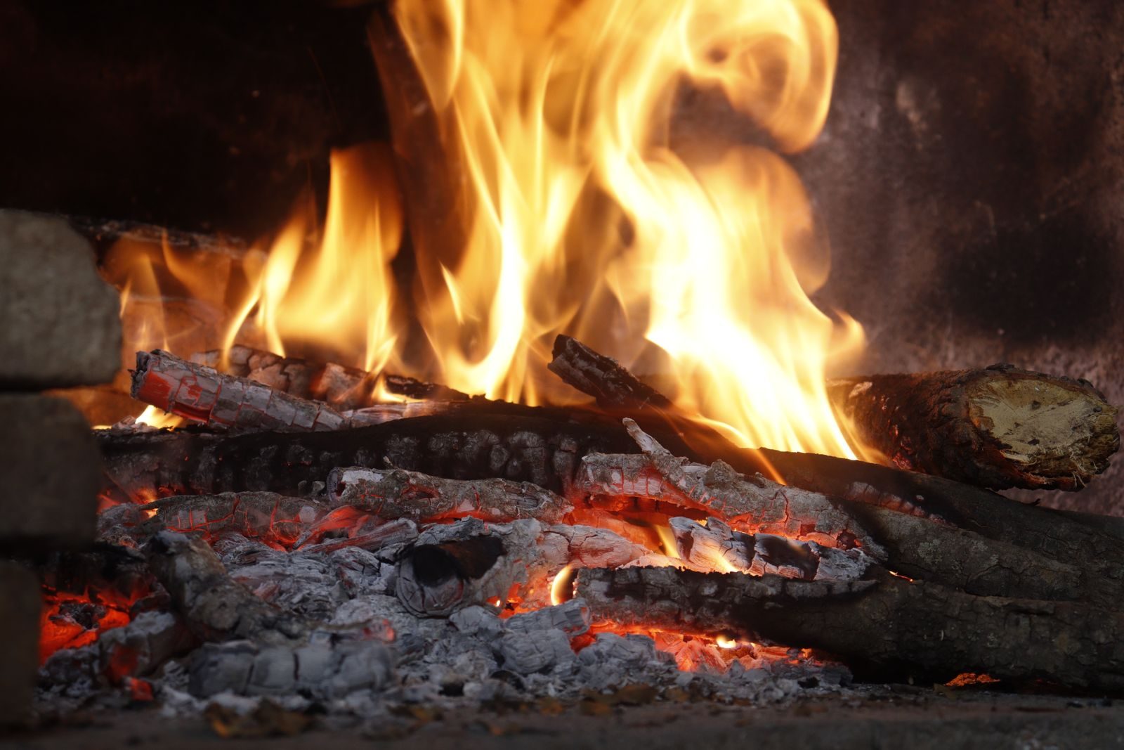 Un feu de bûches dans un foyer, avec flammes et braises